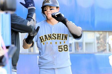 ６回、小野寺の適時右前打で生還し、ベンチでナインとタッチを交わす前川