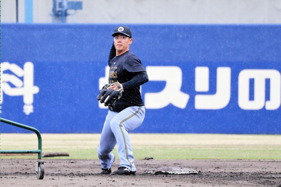 降りしきる雨の中、守備練習する谷端