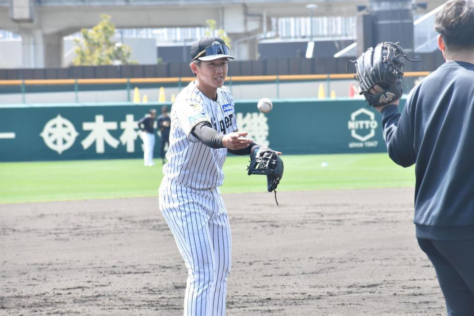 トレーナーへボールを渡す立石