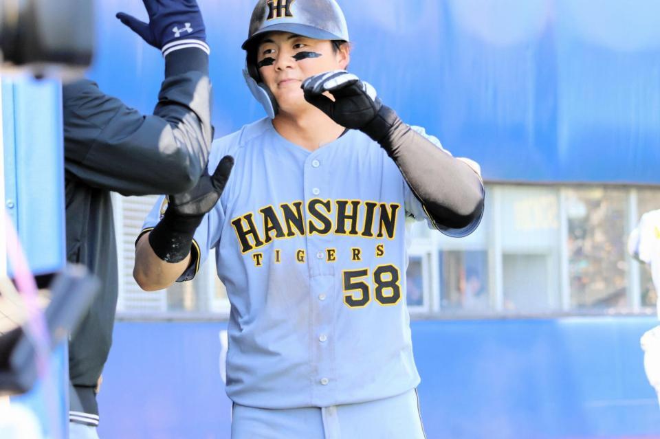 ６回、小野寺の適時右前打で生還し、ベンチでナインとタッチを交わす前川