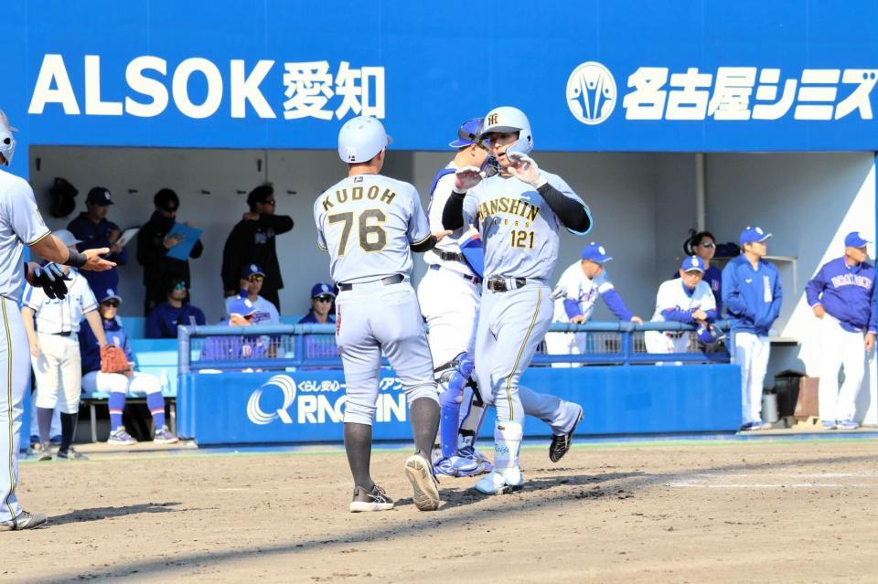 ９回、左越え本塁打を放った戸井（右）は本塁に生還し、工藤２軍外野守備走塁コーチとタッチをかわす