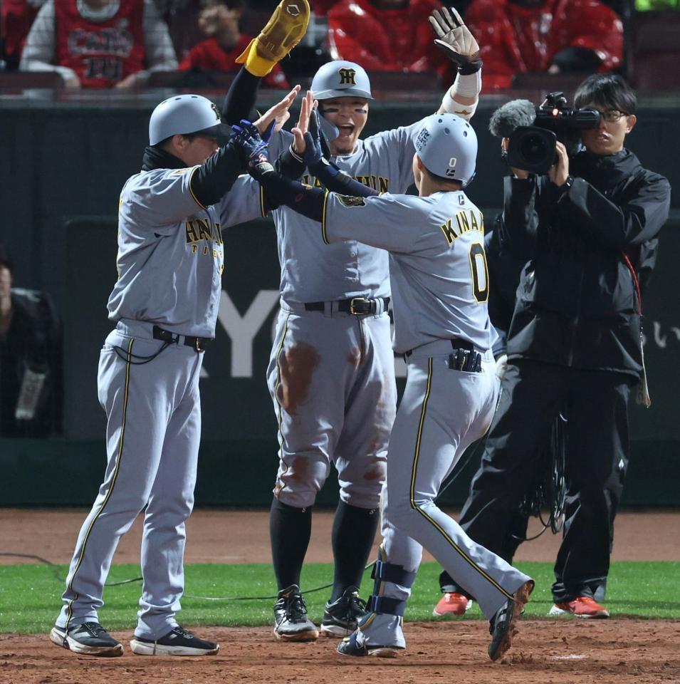 １０回、勝ち越し２ランを放った木浪を迎える佐藤輝（中央）＝撮影・山口登