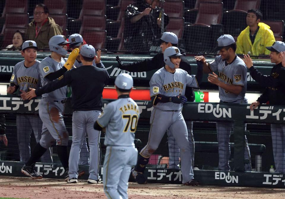 １０回、勝ち越し２ランを放ちナインに迎えられる木浪（中央右）＝撮影・山口登