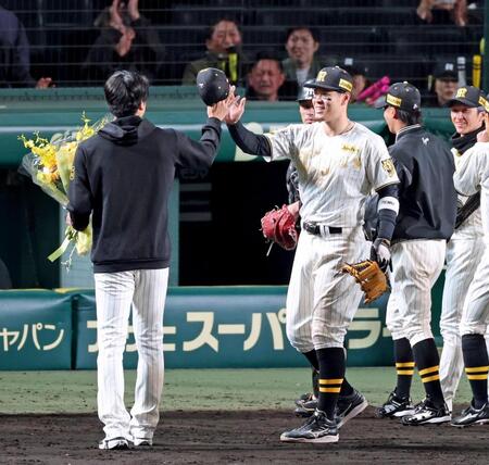 １試合最多奪三振のセ・リーグ記録を達成した才木（左）を祝福する佐藤輝（撮影・立川洋一郎）