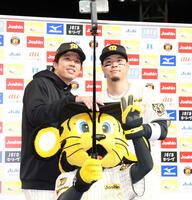 お立ち台でトラッキーと写真に納まる才木（左）と佐藤輝（撮影・西田忠信）