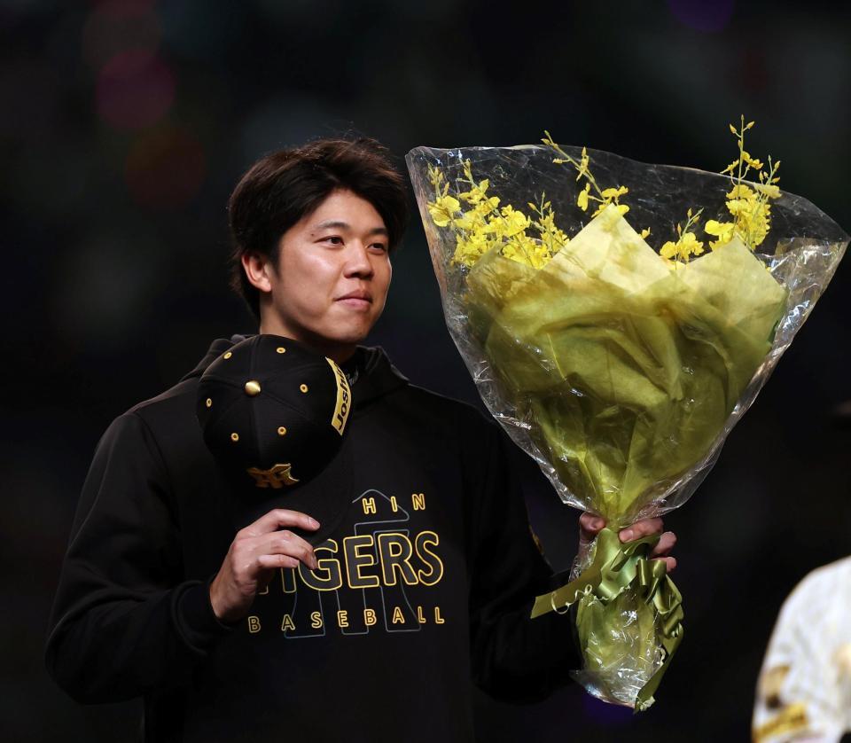 セ・リーグ１試合奪三振記録に並ぶ１６奪三振を記録し花束を手にする才木（撮影・西田忠信）