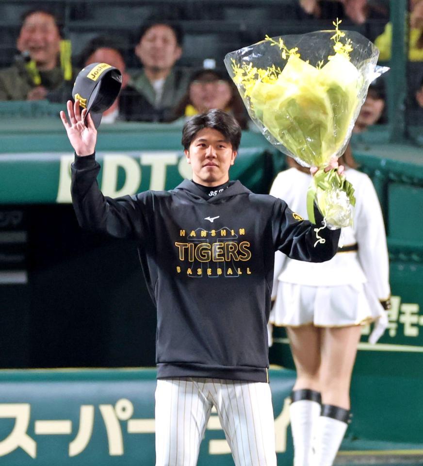 １６三振を奪い、１試合最多奪三振のセ・リーグ記録を達成し花束を掲げる才木（撮影・立川洋一郎）