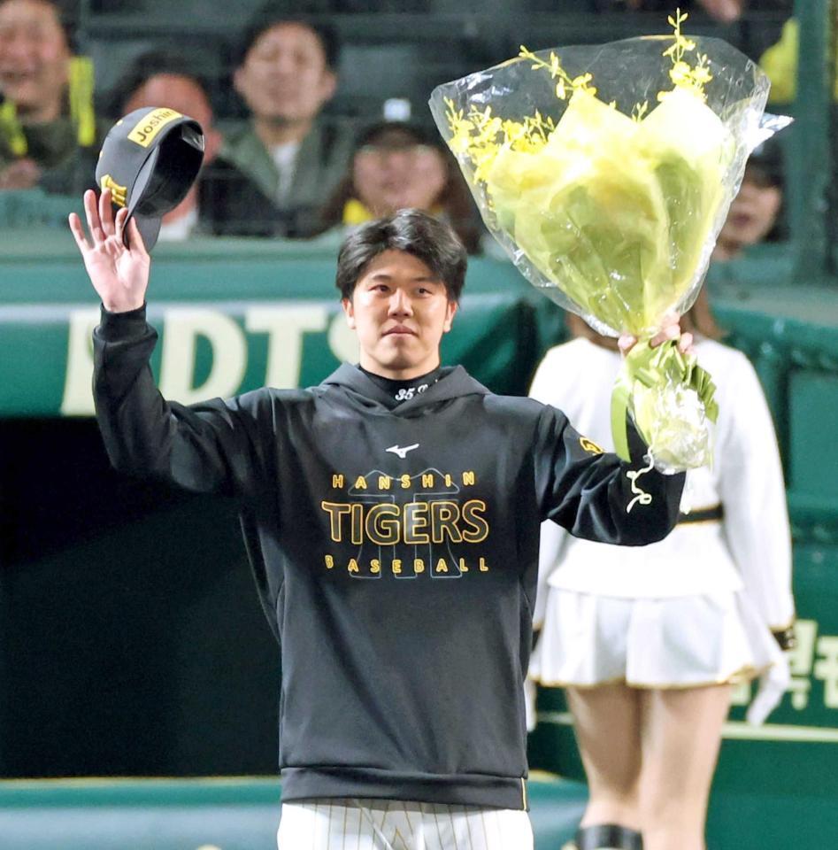 　花束を手にファンの歓声に応える才木