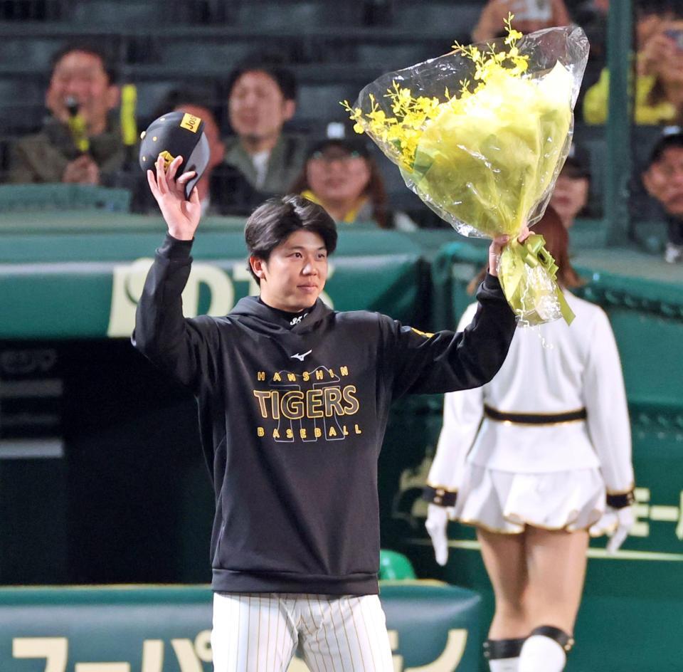 １６三振を奪い、１試合最多奪三振のセ・リーグ記録を達成し花束を掲げる才木（撮影・立川洋一郎）