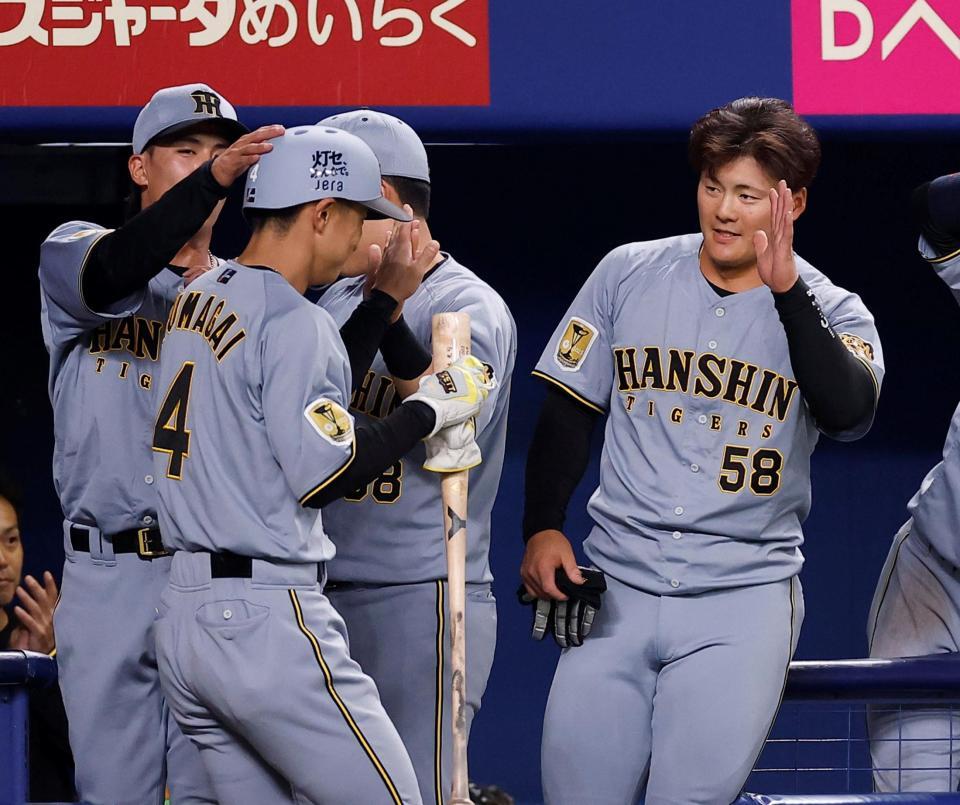 ９回、近本の適時二塁打で生還した熊谷を迎える前川（右）＝撮影・西田忠信