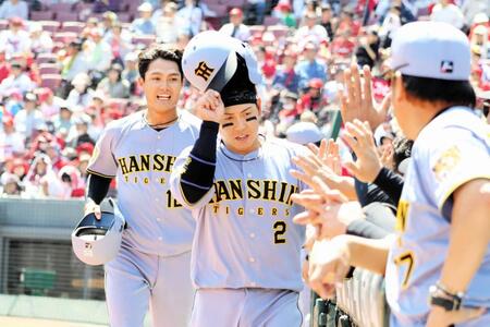 ２回、ディベイニーの２点適時二塁打で生還した梅野（中央）と西純はベンチでナインに迎えられる