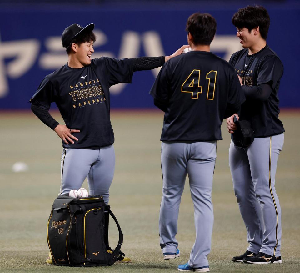 阪神・石黒佑弥（右）に笑顔でボールを突き出す阪神・伊原陵人（左）＝バンテリンドーム（撮影・西田忠信）