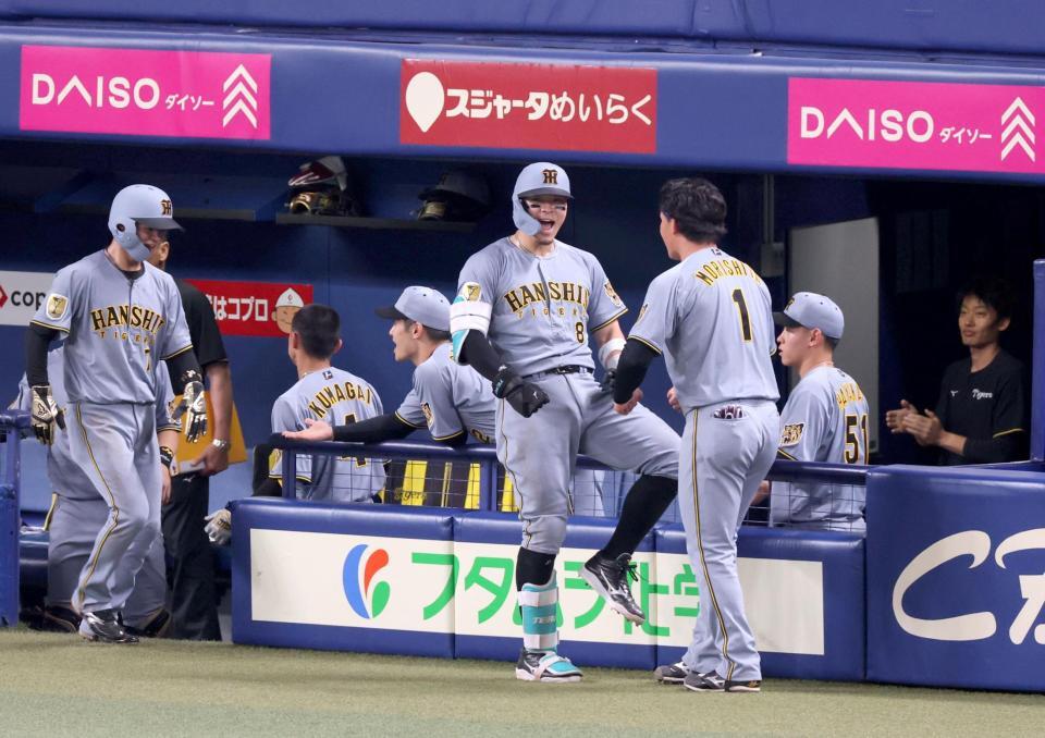 ９回、２ランを放って生還し、森下（１）と雄たけびを上げる佐藤輝（撮影・立川洋一郎）