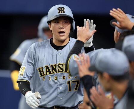 ４回、犠飛を放ちナインに迎えられる伏見（撮影・山口登）