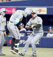 　７回、３ランを放った佐藤輝（左）を迎える森下（撮影・山口登）