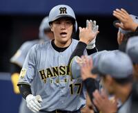 ４回、犠飛を放ちナインに迎えられる伏見（撮影・山口登）