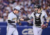 ７回を投げ終え伏見（右）とタッチを交わす高橋