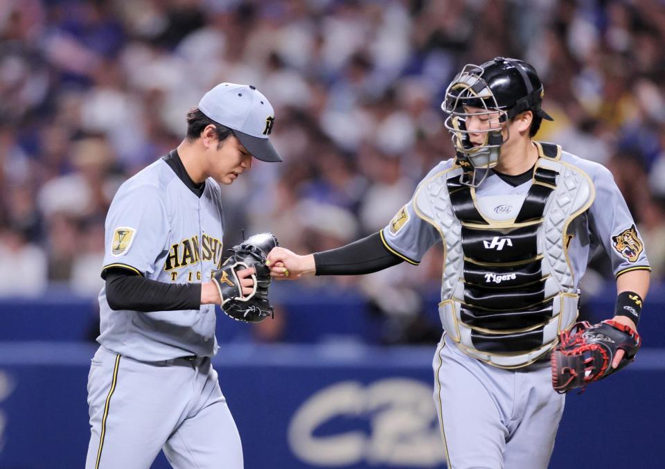 ７回を投げ終え伏見（右）とタッチを交わす高橋