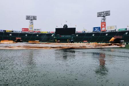 雨が降り続き、グラウンドにはシートが敷かれている＝（撮影・山口登）