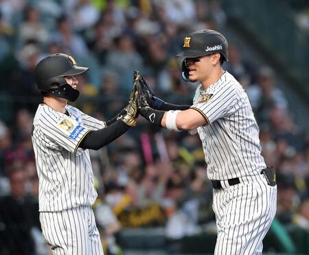 ２回、２ランを放ち中野（左）とタッチを交わす佐藤輝（撮影・西田忠信）