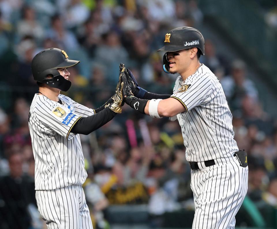 ２回、２ランを放ち中野（左）とタッチを交わす佐藤輝（撮影・西田忠信）