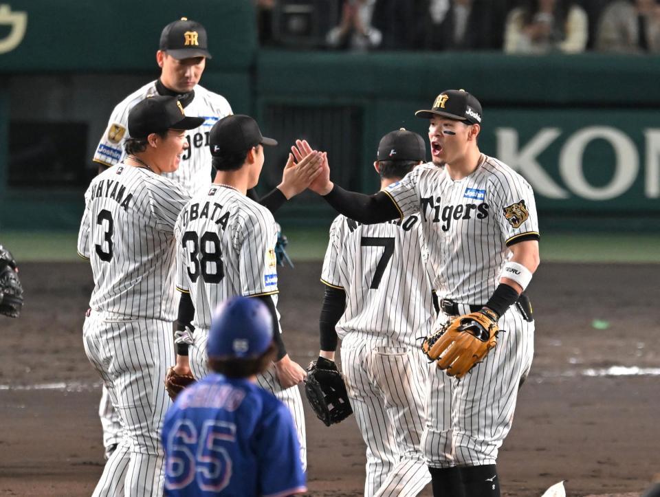 勝利のハイタッチを交わす佐藤輝（右）と大山（撮影・飯室逸平）