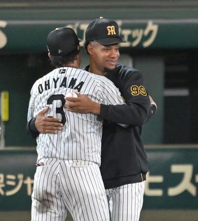 甲子園初勝利のウインイングボールを手に阪神・大山悠輔と抱き合う阪神　ダウリ・モレッタ＝１７日