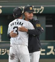 甲子園初勝利のウインイングボールを手に阪神・大山悠輔と抱き合う阪神　ダウリ・モレッタ＝１７日