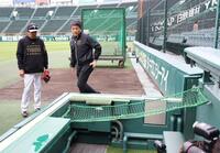 カメラマン席に設置されたネットを確認する阪神・藤本敦士総合コーチ（左）＝撮影・西田忠信