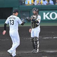 ９回からマスクをかぶり、マウンドで岩崎とタッチを交わす梅野（撮影・飯室逸平）