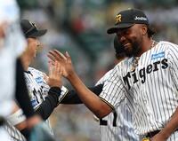 　勝利後、藤川監督（左）と笑顔でタッチを交わすドリス（撮影・西田忠信）