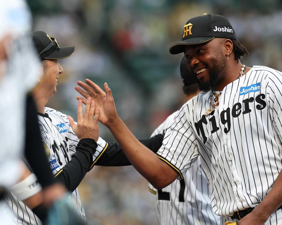 　勝利後、藤川監督（左）と笑顔でタッチを交わすドリス（撮影・西田忠信）