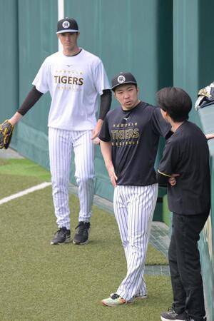 歩行練習後、トレーナーと雑談する石井。左はルーカス（撮影・金居みつよし）