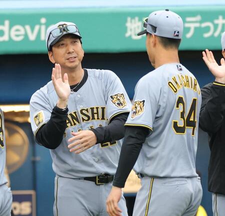 プロ初安打を放った岡城快生（右）とタッチを交わす藤川監督（撮影・西岡正）