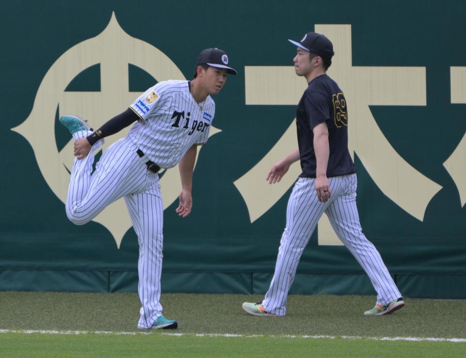 ケガ後初の外野で歩行練習する石井。左は立石（撮影・金居みつよし）