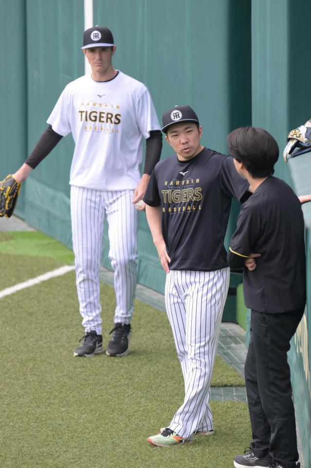 歩行練習後、トレーナーと雑談する石井。左はルーカス（撮影・金居みつよし）