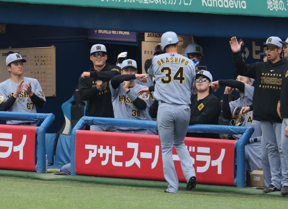 ３回、先制適時二塁打を放った岡城を祝福する阪神ナイン（撮影・金田祐二）