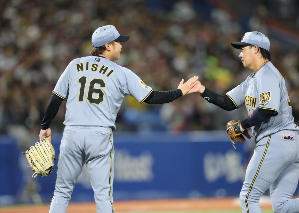 ４回、好守の大山（右）とタッチを交わす西勇（撮影・西岡正）