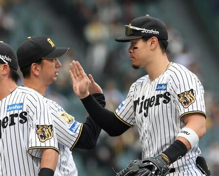 勝利後、藤川監督（左）とタッチを交わす佐藤輝（撮影・西田忠信）