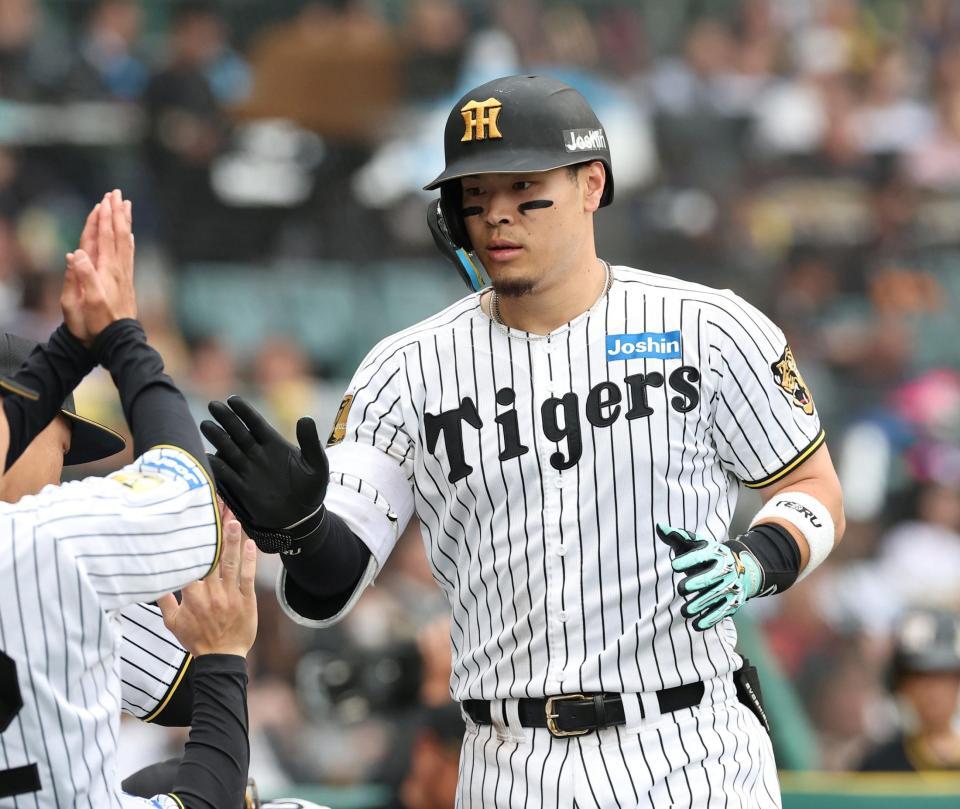 ８回、ソロを放ちベンチ前で迎えられる佐藤輝（撮影・西田忠信）
