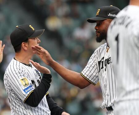 最後を締め、藤川監督（左）とタッチを交わすドリス（撮影・西田忠信）