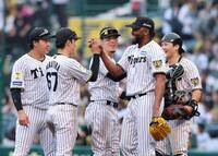 通算１００セーブを達成したドリスは笑顔でナインとタッチする（撮影・山口登）