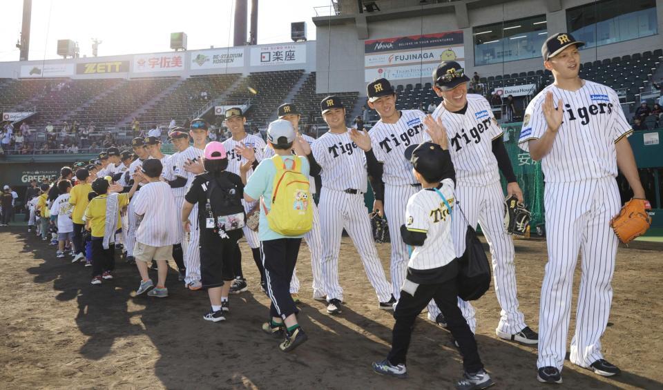 　野球教室を終え、子どもたちとタッチを交わす阪神ナイン（撮影・坂部計介）