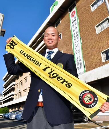 ドラフト指名を祝う垂れ幕の前で笑顔を見せる亜大・高橋遥人＝２０１７年１１月撮影