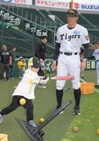 ティー打撃をする子供を見守る阪神ＯＢ糸井氏＝６日