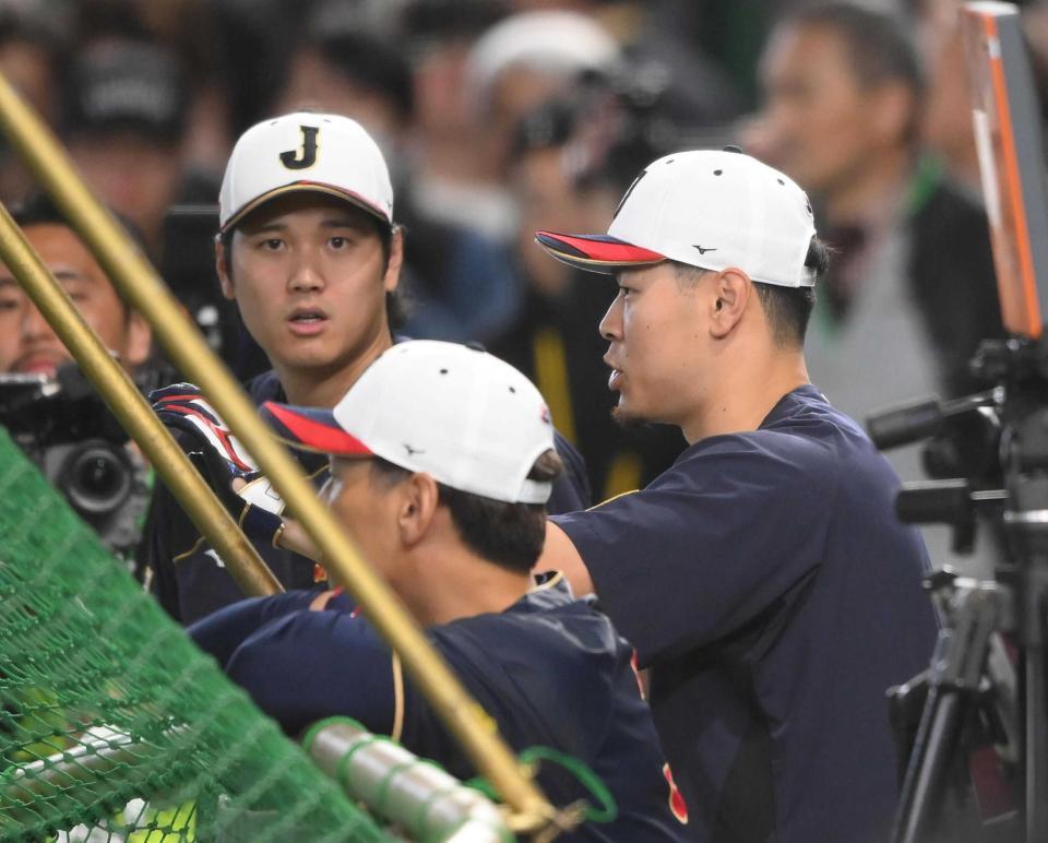 試合前に打撃練習を行った阪神・佐藤輝明。左はドジャース・大谷翔平＝３月