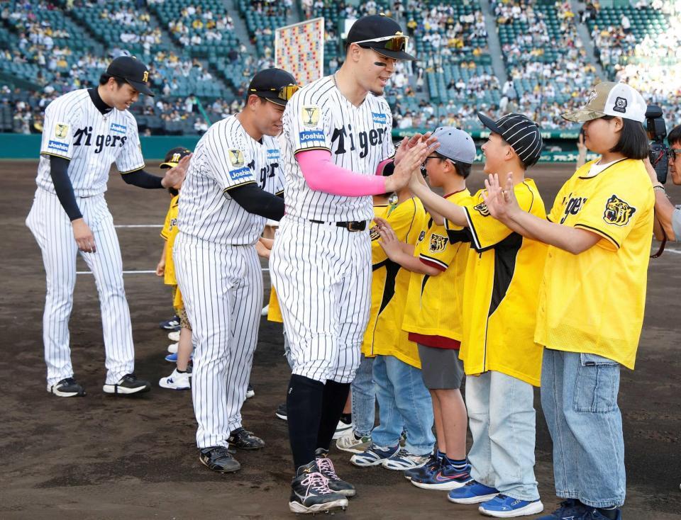 　子どもたちとタッチを交わす（右から）佐藤輝、嶋村、才木（撮影・西田忠信）