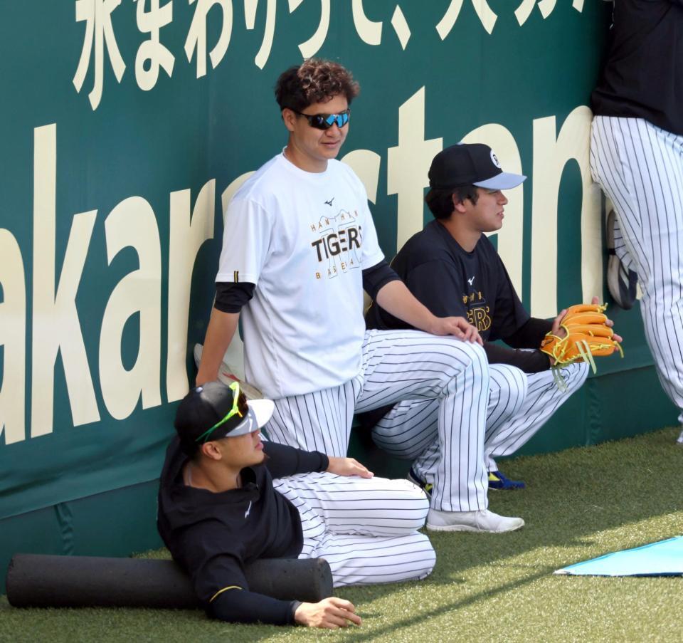 フェンス際でストレッチする大竹（中央）＝撮影・山口登