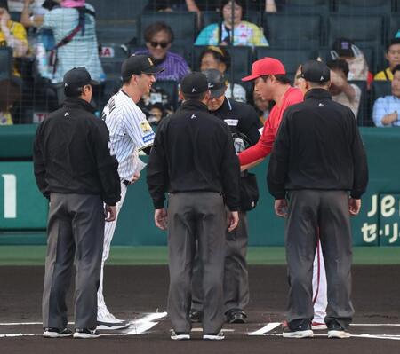 試合前、メンバー表を交換し握手する藤川監督と新井監督（撮影・山口登）