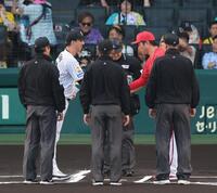 試合前、メンバー表を交換し握手する藤川監督と新井監督（撮影・山口登）
